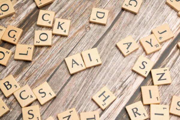 Wooden letter tiles scattered on a textured surface, spelling 'AI'. — Photo by Markus Winkler on Pexels