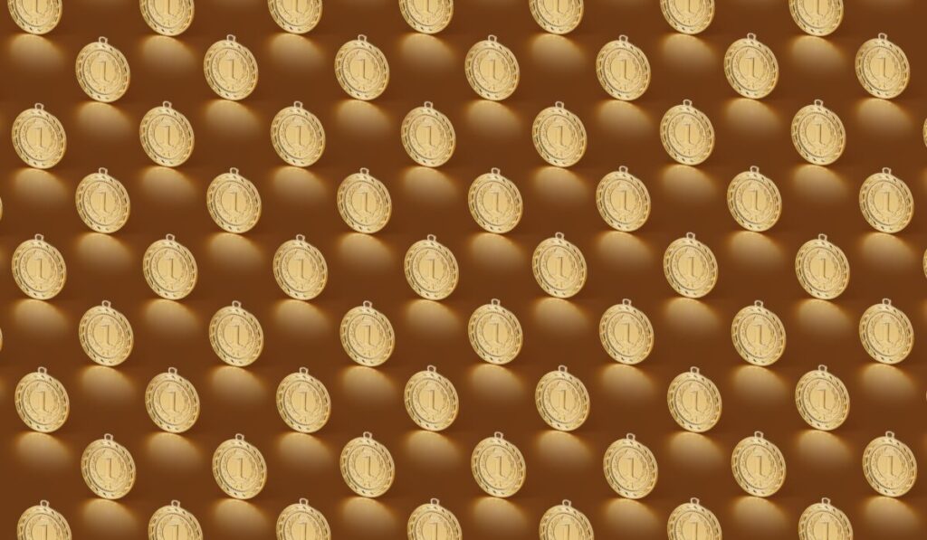 Multiple gold medals arranged in a repeating pattern on a brown backdrop. — Photo by DS stories on Pexels