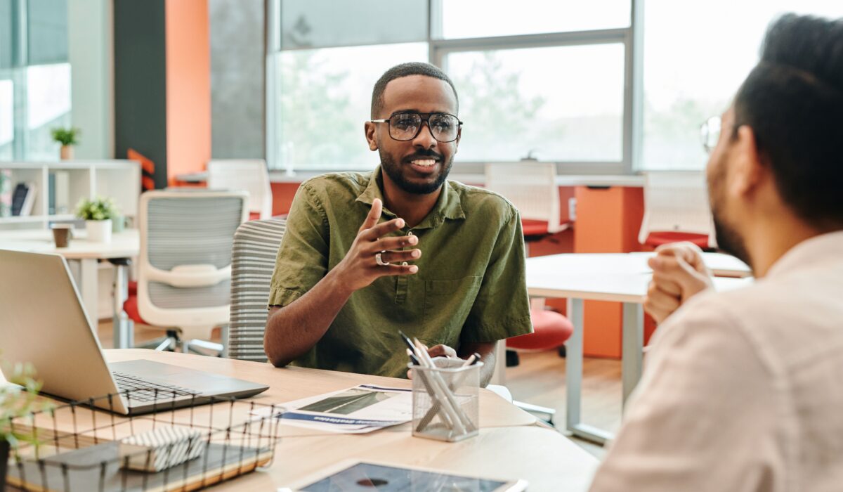 Two professionals engage in a casual meeting in a modern office setting. — Photo by Edmond Dantès on Pexels